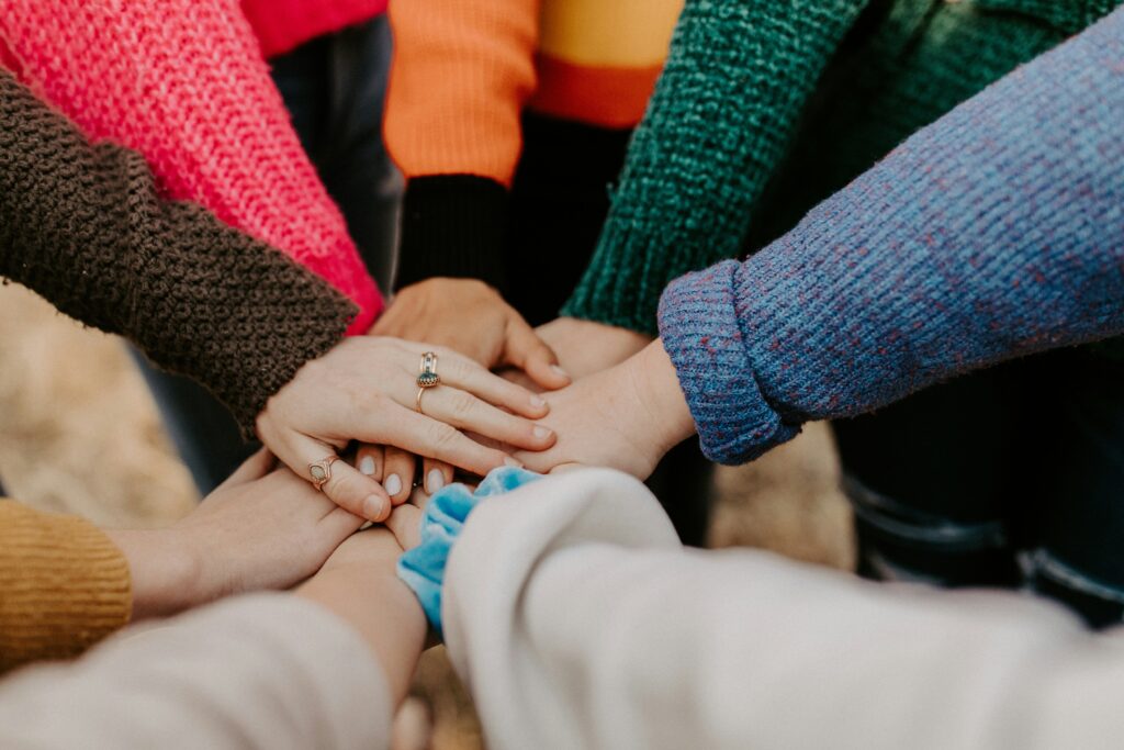 Diverse hands coming in for a huddle.