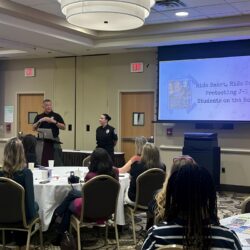Two safety patrol officers present at a conference for Work & Travel USA.