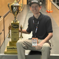 Young man posing with huge trophy