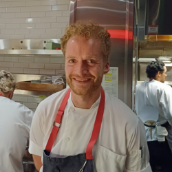 Man in apron posing in kitchen